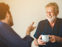 Two people talking with a hot drink